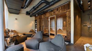 Unwind in a serene space with a comfortable seating area, sauna access, and a modern shower.