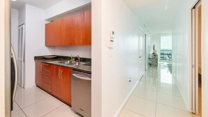 A modern kitchen with wooden cabinets, a stainless steel sink, and a dishwasher. - 4309 the club  · PENTHOUSE Oceanview 4bedroom freeparking @brickell (Miami)