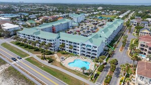 Un resort con una gran piscina, varias edificaciones y una carretera al frente.