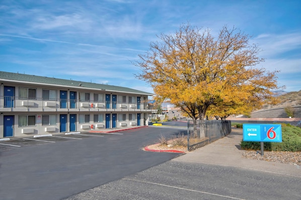 Un motel doté d’un parking et d’un panneau indiquant le numéro de la chambre 6.