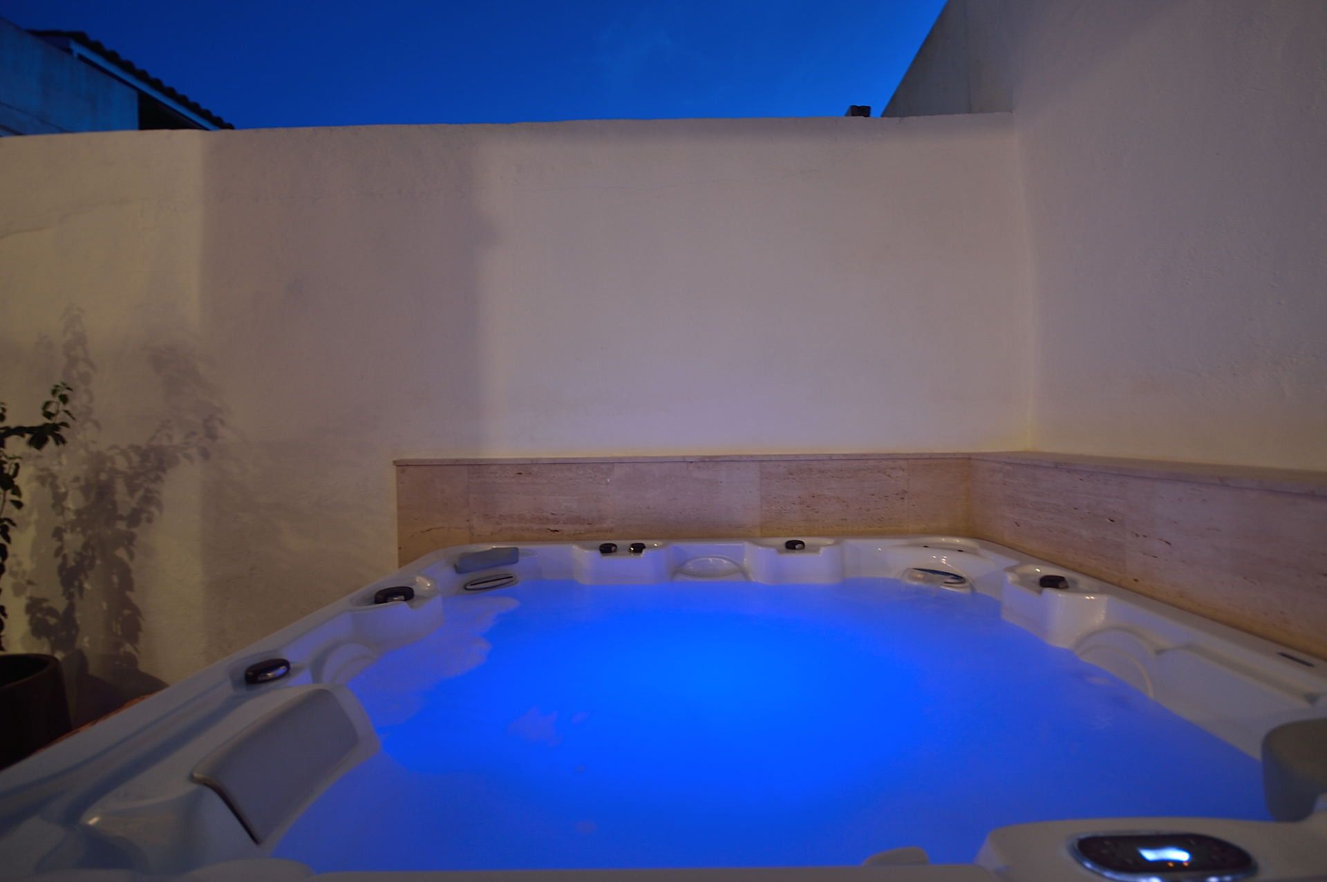A hot tub with a wooden headboard and a blue light.