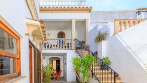 A courtyard with a staircase, a dining area, and a potted plant. - Casa Torres (Pollensa / Pollença)