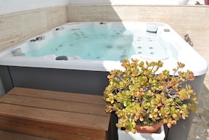 A hot tub with a wooden bench in front, and a potted plant beside it. - Casa Torres (Pollensa / Pollença)