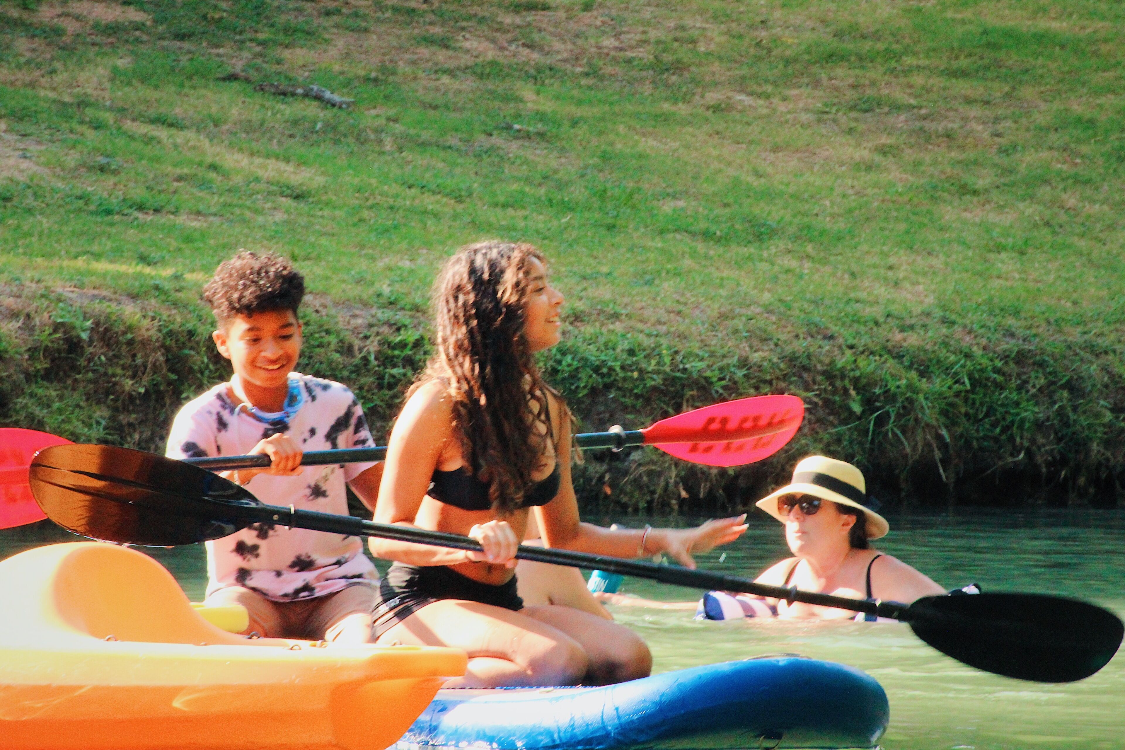 Trois personnes dans un kayak sur une rivière.