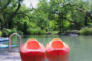 A serene outdoor setting with a wooden dock and two red paddle boats.