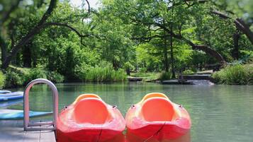 A serene outdoor setting with a wooden dock and two red paddle boats.