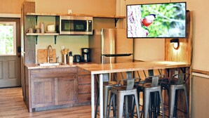 Una cucina moderna con microonde, macchina del caffè e sgabelli da bar in legno.