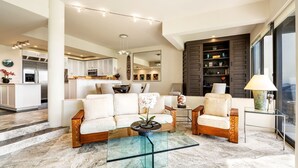 A modern living room with a sofa, armchairs, a glass coffee table, and a dining area in the background. - 🏖️Updated Ground Floor Mauna Lani Condo on the Golf Course (Kamuela)