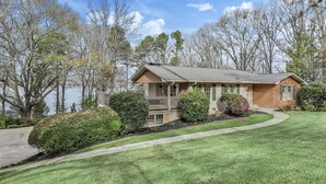 A two-story house with a front porch, a driveway, and a well-maintained lawn.