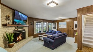A living room with a fireplace, a television, and a sofa.