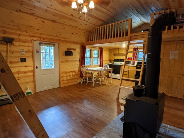 L’intérieur d’une cabane en bois comprend un coin repas, une cuisine et un espace aménagé en mezzanine.