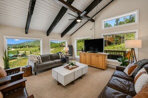 A spacious living room with a large television, comfortable seating, and a view of a mountainous landscape. - Pet Friendly, Great Views, Great For Large Groups (Crested Butte)