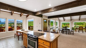 A spacious kitchen with a central island, wooden cabinets, and large windows offering scenic views. - Pet Friendly, Great Views, Great For Large Groups (Crested Butte)