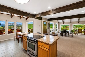 A spacious kitchen with a central island, wooden cabinets, and large windows offering scenic views. - Pet Friendly, Great Views, Great For Large Groups (Crested Butte)