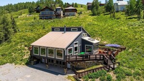 A modern house with a deck, surrounded by a lush green landscape. - Pet Friendly, Great Views, Great For Large Groups (Crested Butte)