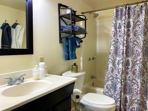 A bathroom with a sink, mirror, towel rack, toilet, and shower curtain. - Jennywood Cottage - Prescott Cabin Rentals (Prescott)