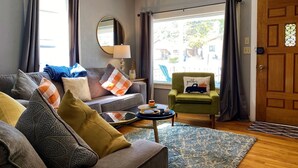 Una sala de estar acogedora con un sofá, un sillón y una pequeña mesa con una lámpara.