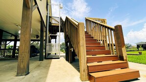 Una escalera de madera que lleva a un nivel superior de un edificio con un espacio exterior cubierto.