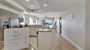 Una cocina moderna con encimeras de granito, electrodomésticos de acero inoxidable y una isla grande.
