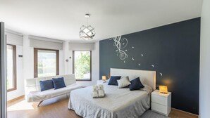 Une chambre moderne avec un grand lit, un canapé et un bureau.