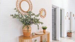 A hallway with a woven basket vase, a small potted plant, and a mirror on a wooden console table. - Villa Universal Beauty Resort Torrox by Ruralidays (Málaga)