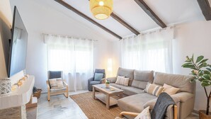 A living room with a sofa, armchairs, a coffee table, a TV, and a plant. - Villa Universal Beauty Resort Torrox by Ruralidays (Málaga)