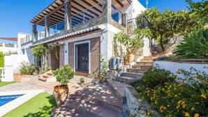 A modern house with a swimming pool, a large potted plant, and a staircase leading to the entrance. - Villa Alberto Frigiliana by Ruralidays (Málaga)