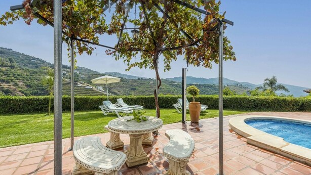 A poolside area with a pergola, outdoor seating, and a view of the countryside. - Casa La Lomilla Canillas de Albaida by Ruralidays (Málaga)