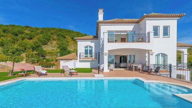 A two-story house with a swimming pool, outdoor seating, and a view of a green hillside. - Villa Latina Golf Arcos de la Frontera by Ruralidays (Cádiz)