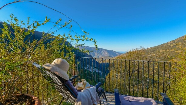 A person reclining on a hammock with a book, overlooking a mountainous landscape. - Buenavista de Bubión by Ruralidays (Granada)