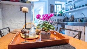 A wooden dining table with a tray, a candle, a potted plant, and a jar of honey. - Casa Shyshka Periana by Ruralidays (Málaga)