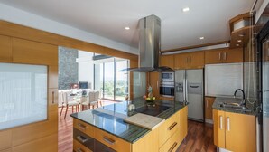 A modern kitchen with a central island, stainless steel appliances, and wooden cabinetry. - Idem Rural Baza by Ruralidays (Granada)