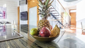 A bowl of fruit on a marble countertop in a modern kitchen with a staircase in the background. - Idem Rural Baza by Ruralidays (Granada)