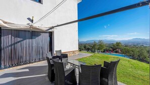 A patio with a table and chairs, a pool, and a view of the landscape. - Idem Rural Baza by Ruralidays (Granada)