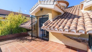 A residential building with a tiled roof, a gated entrance, and a balcony with a tiled floor. - Casa Rural cerca de Granada Otura by Ruralidays (Granada)