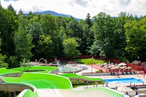 Ein Wasserpark mit Rutschen und Poolanlage, umgeben von Bäumen.