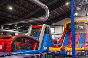 Ein Indoor-Spielbereich mit Hüpfburgen und Kletterwänden.