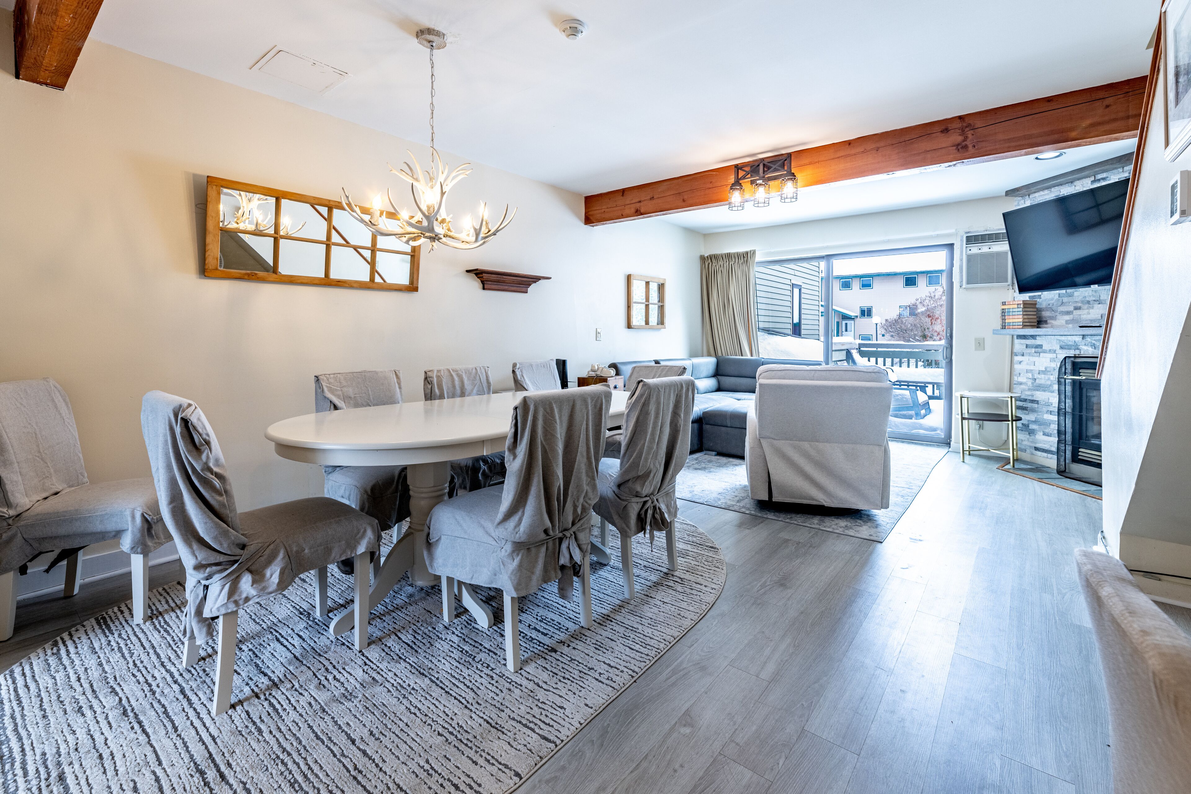 Una sala de estar moderna con comedor, chimenea y un amplio ventanal con vistas a la ciudad.