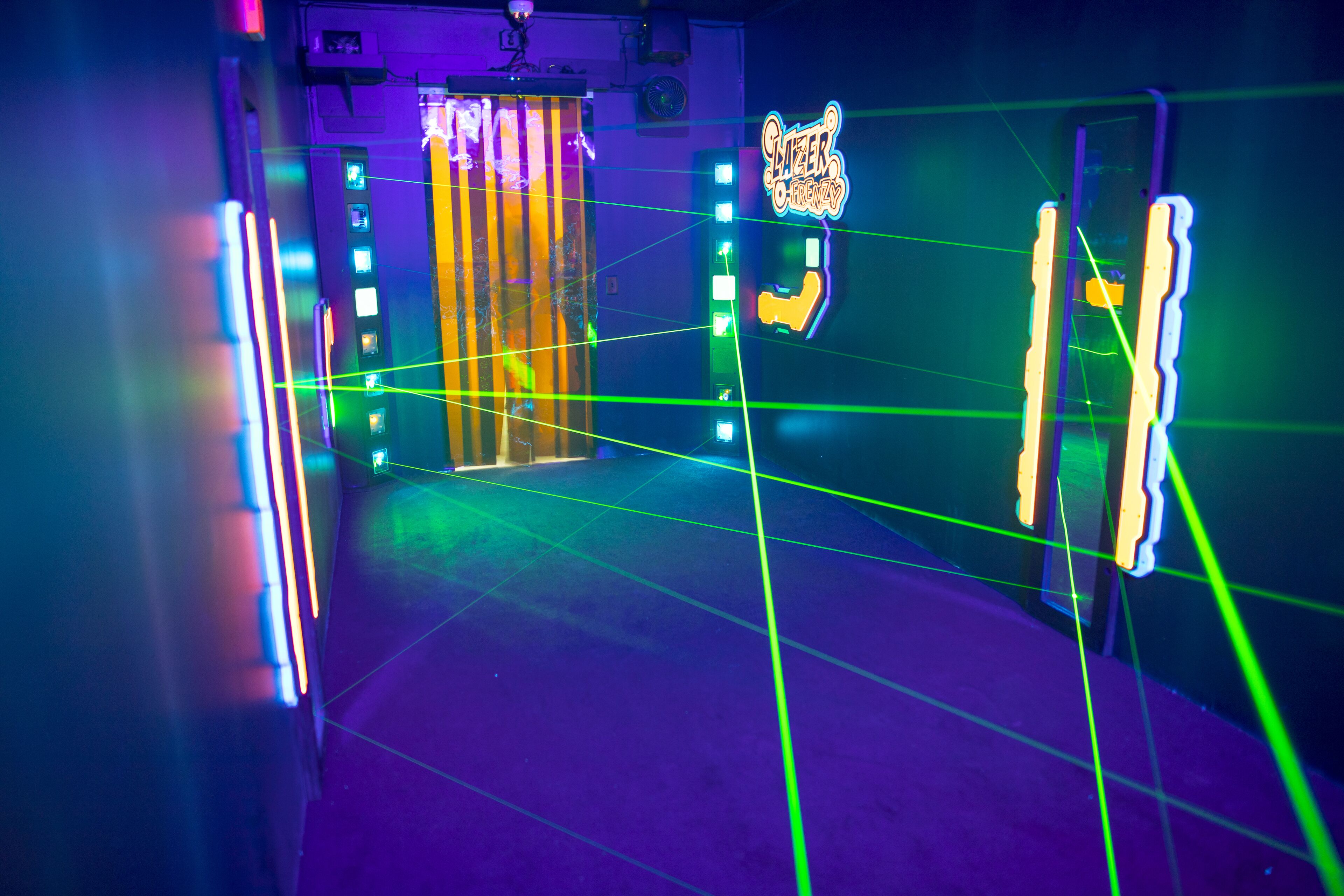 A room with a neon sign, a door, and a wall with a neon light.