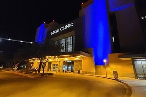 A building with a sign that reads 'MAYO CLINIC' at night. - Stunning $100K+ Remodel! Peaceful Location, Heated Pool, Spa, BBQ, Fire Pit, EV (Scottsdale)