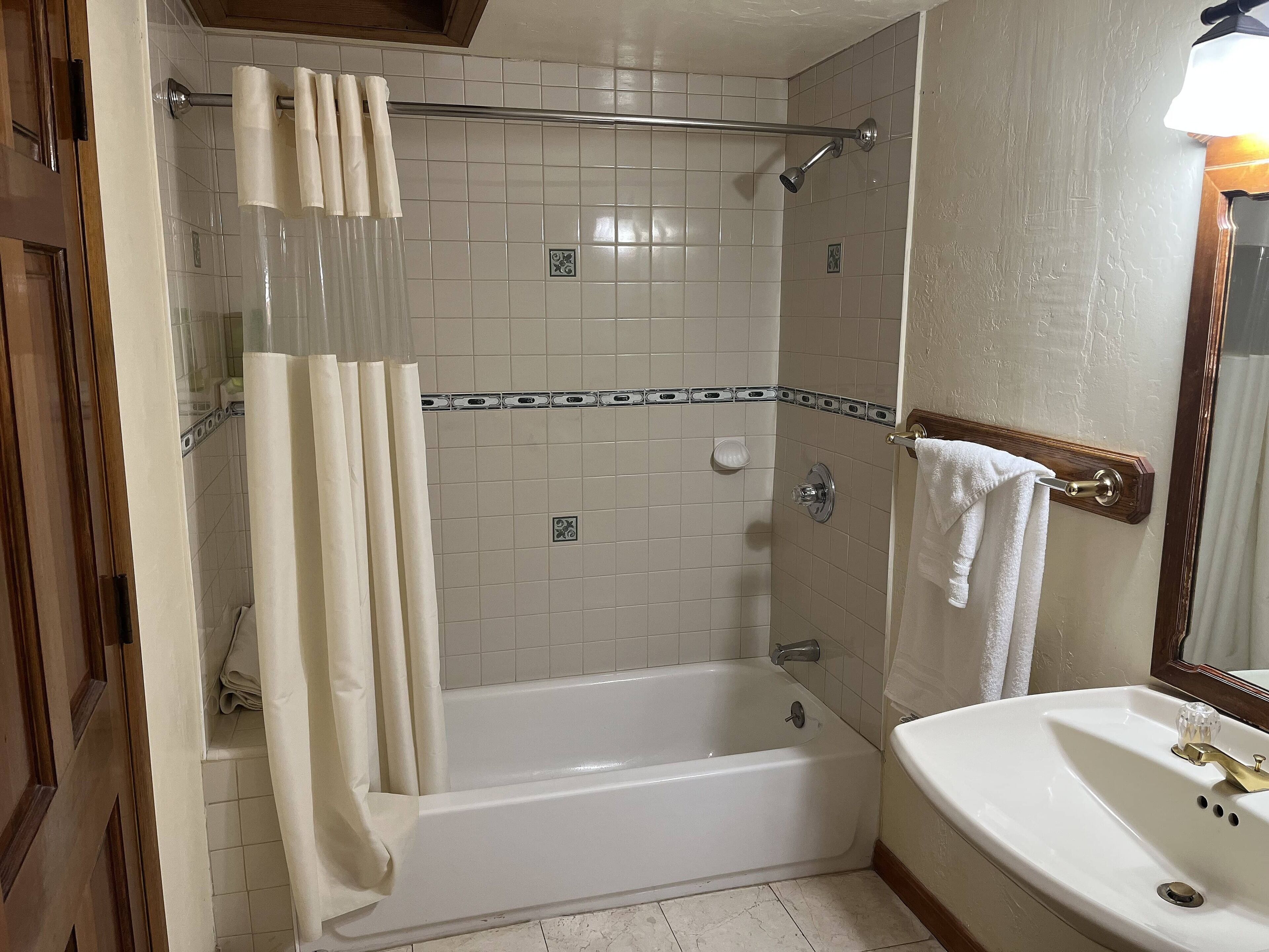 Une salle de bain avec une baignoire, un lavabo et une douche.