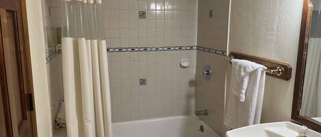 Une salle de bain avec une baignoire, un lavabo et une douche.