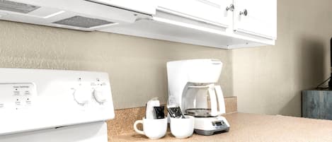 Une cuisine équipée d’un four encastré, d’une machine à café et d’un four à micro-ondes.