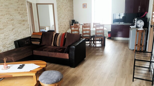 Una sala de estar moderna con un sofá seccional, una mesa de comedor de madera y sillas.
