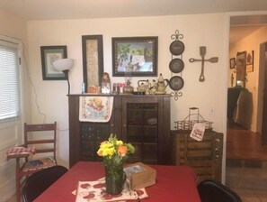 Enjoy meals in this inviting dining area with a table, chair, and vase of flowers.