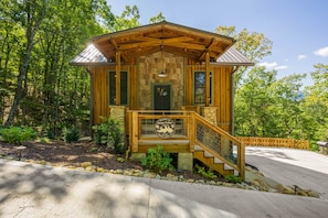 A wooden cabin with a porch, a welcome sign, and a staircase leading to the entrance. - Cute Cabin Near PF/Island Hottub GameRoom 2Bed Sleeps 5 Air Hockey Private (Pigeon Forge)