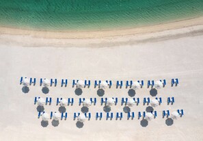 Praia particular, espreguiçadeiras, guarda-sóis, toalhas de praia