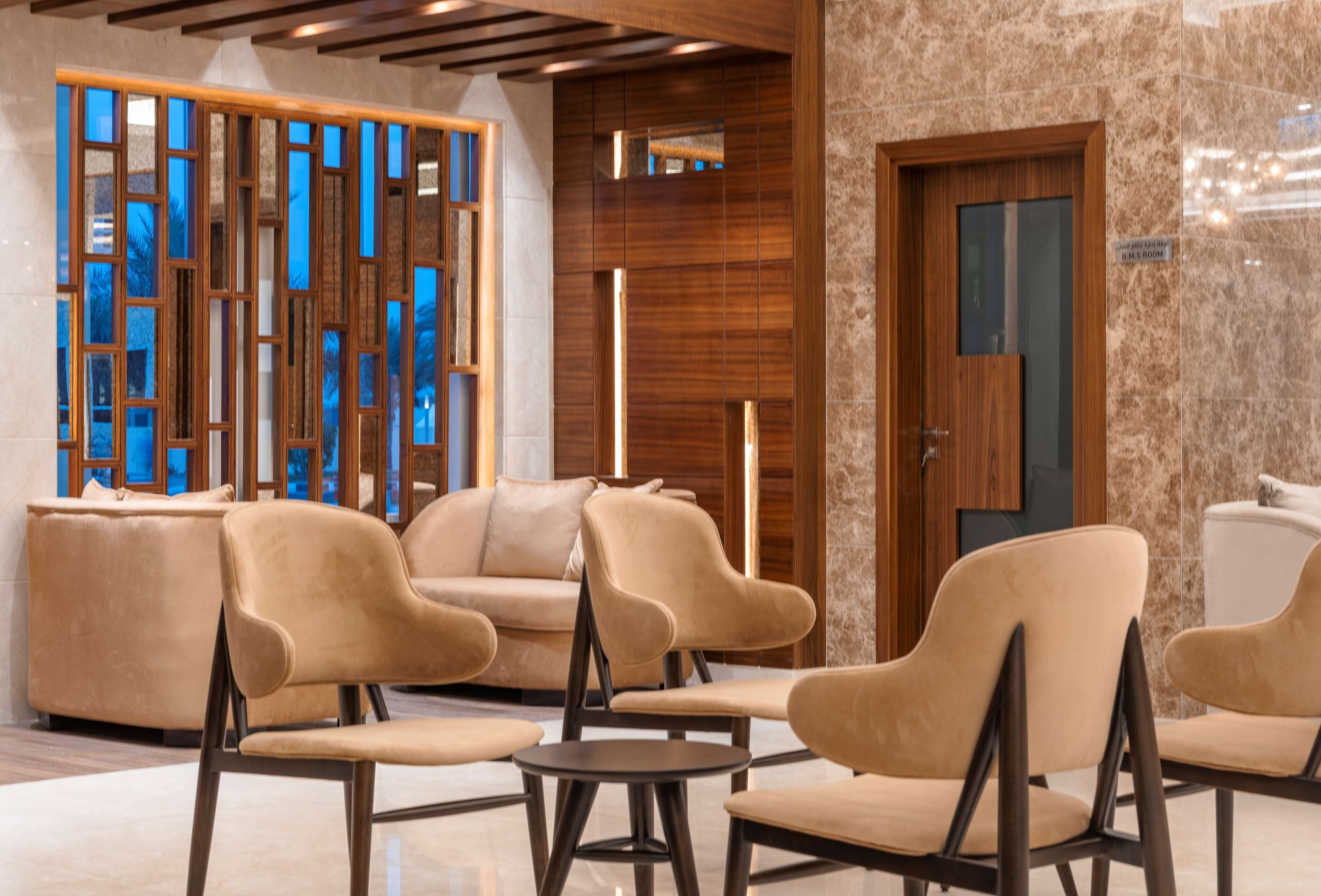 Eine Lobby mit modernen Möbeln, einem Holzbüro und einem großen Fenster mit Blick.