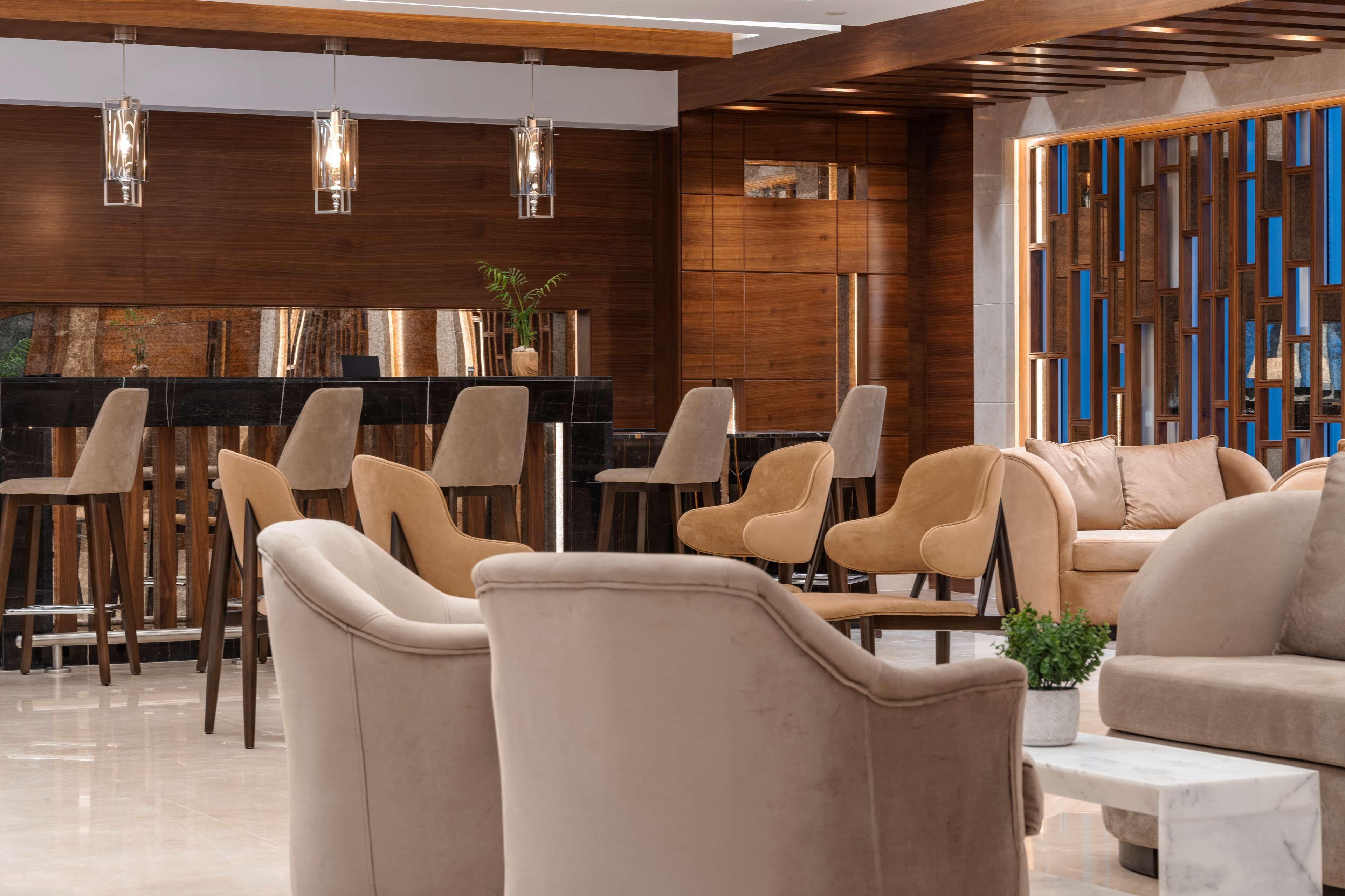 Un interior moderno con una zona de bar, asientos y detalles de madera.