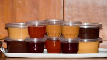 A tray of variously colored jellies or jams in plastic containers.